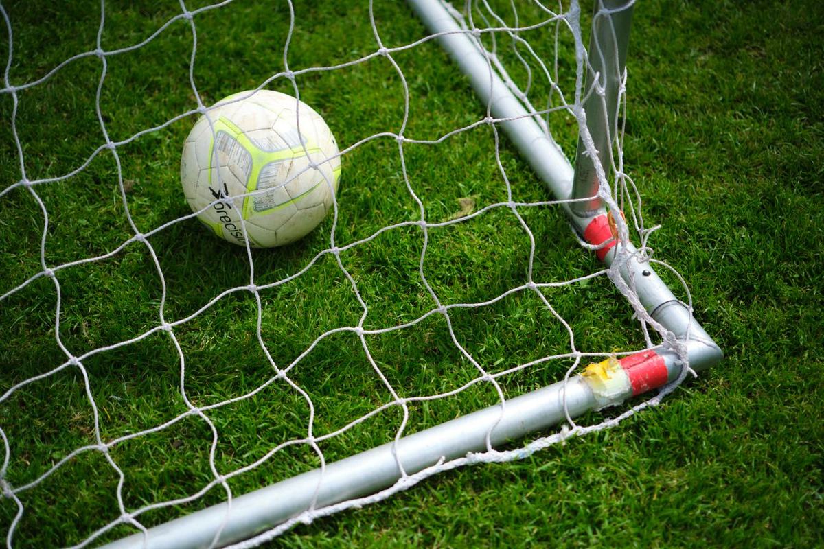 Bola sepak berada di dalam jala gawang