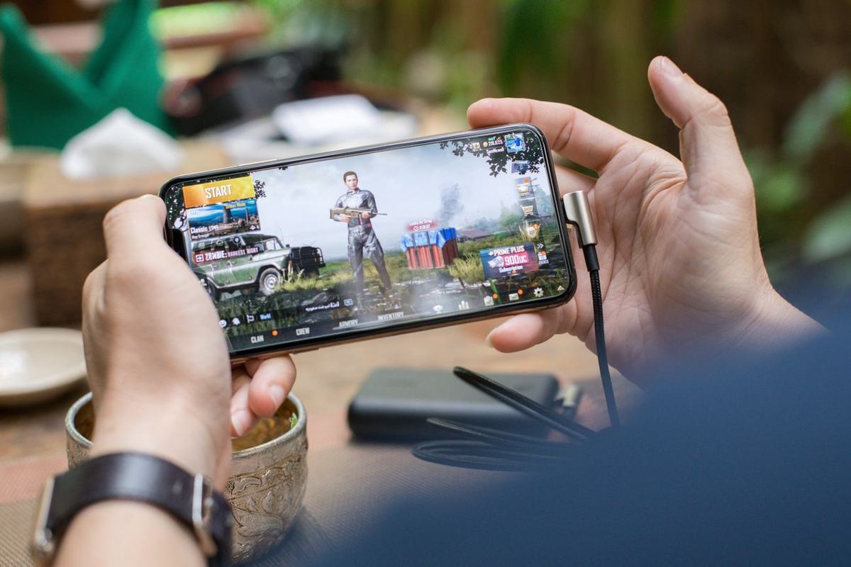 Seseorang memegang ponsel sambil bermain game seluler