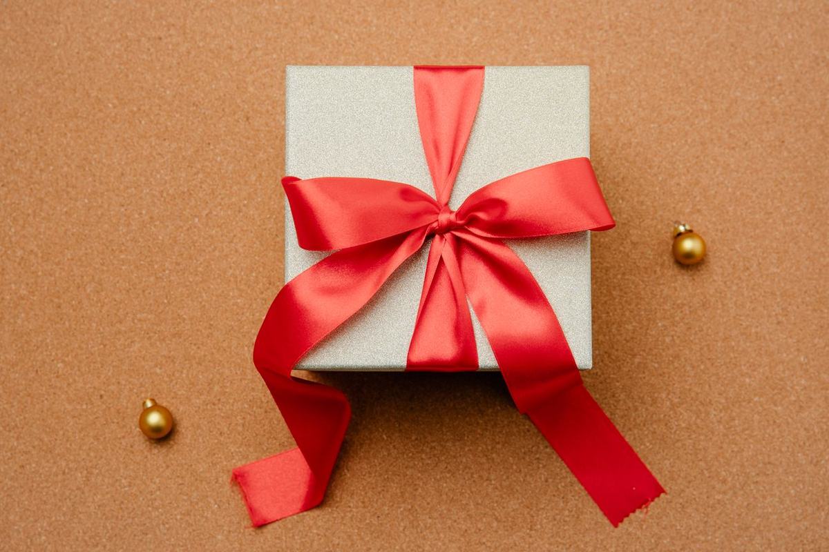 Kotak hadiah dengan pita merah di atas meja